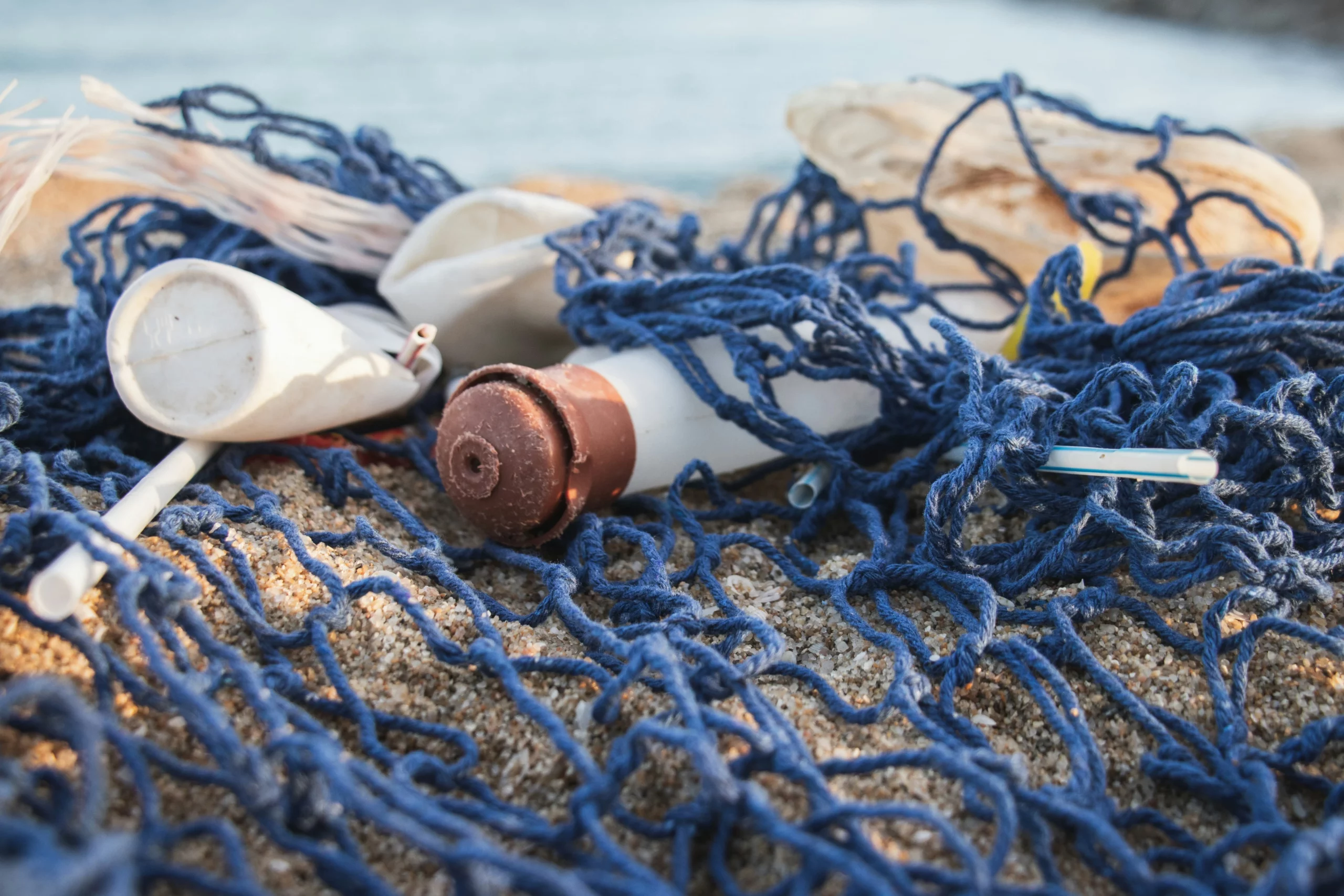 A fishing net with plastic waste washed up on the beach in Barcelona shows the plastic problem in our oceans.