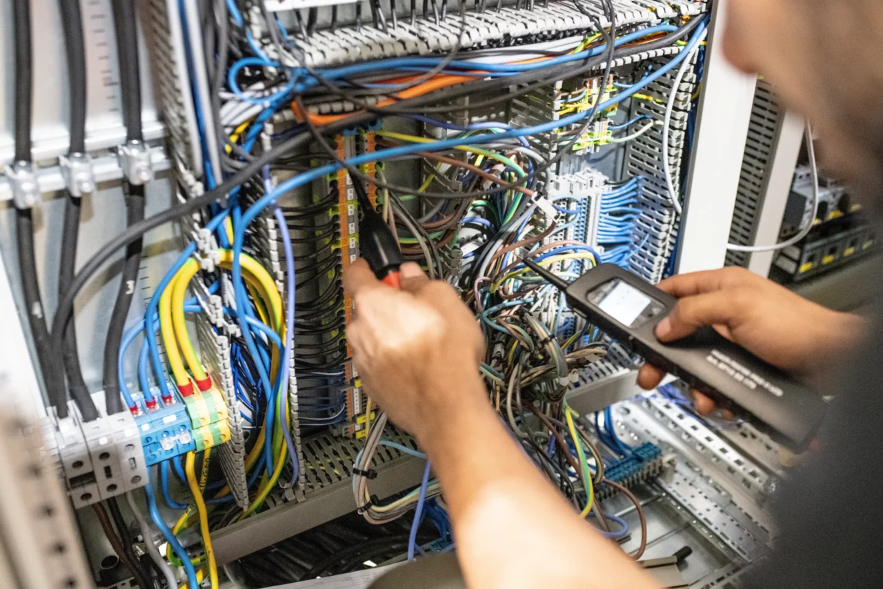 Electrical planner for systems engineering at work on the electrical control cabinet.