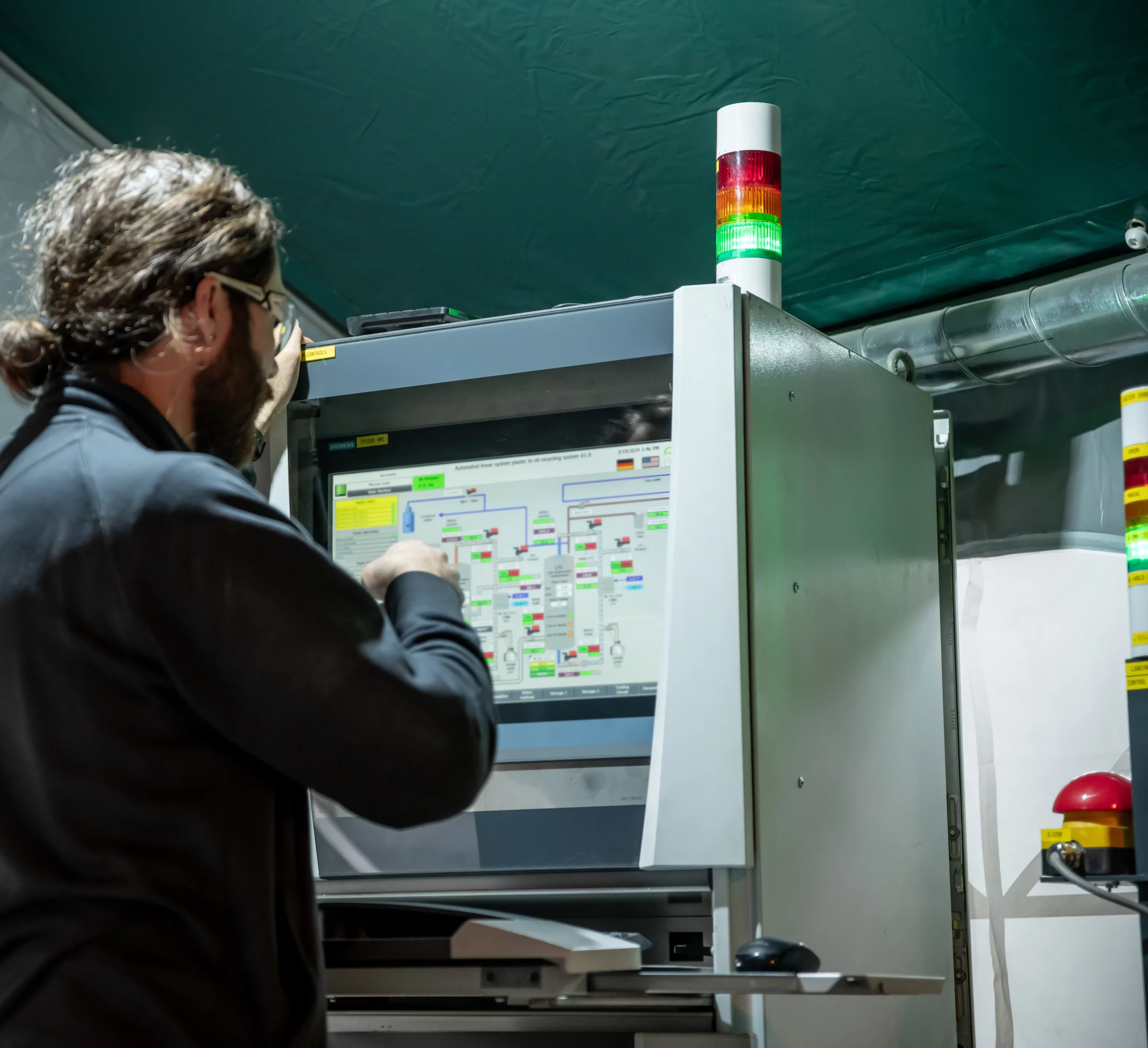 Automatisierungstechniker beim Bedienpanel an der Maschine.