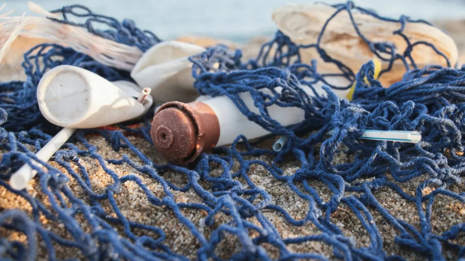 Ein angeschwemmtes Fischernetz mit Plastikmüll zeigt das Plastikproblem unserer Meere am Strand von Barcelona.