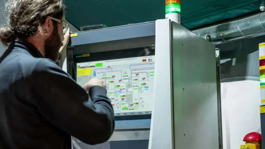 Automation technician at the control panel on the machine.