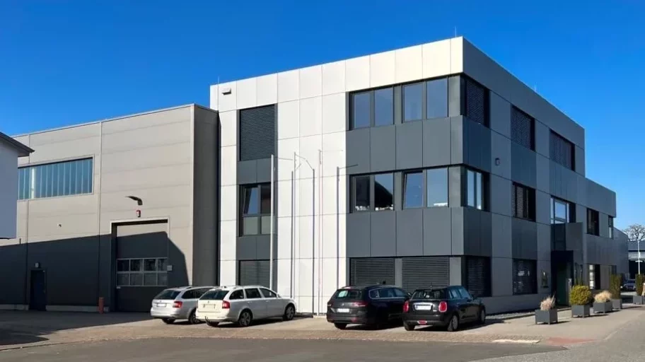 Exterior view of the industrial building in Tangstedt near Hamburg with offices above the entrance and a neighbouring factory hall.