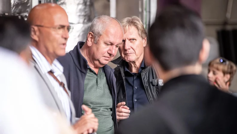 Cyrill Hugi, Jochim Eitner und Klaus-Peter Adolf in Diskussion anlässlich eines Teamausfluges ins Porsche-Museum in Stuttgart.