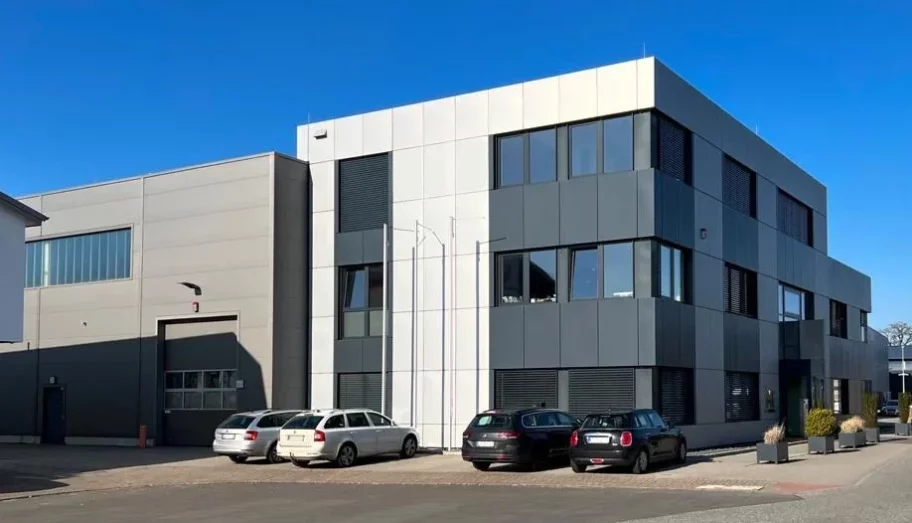 Exterior view of the industrial building in Tangstedt near Hamburg with offices above the entrance and a neighbouring factory hall.